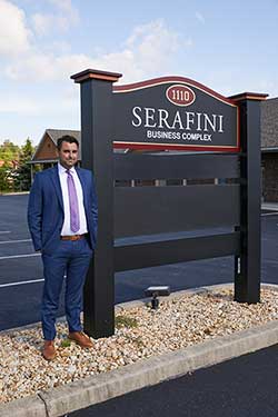 A.J. Serafini standing next to external firm sign at his Law office located at 1110 Opal Court in Hagerstown, Maryland